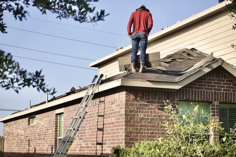 Professional roofer working on a residential roof in Laurelton Gardens